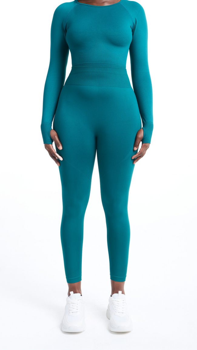 Full view of woman wearing a Turquoise Shavo legging. Matching Shavo Long Sleeved top is also pictured.