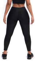 Back waist down view of a woman with a black sports black leggings