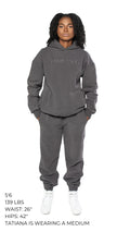 Woman wearing a grey unisex sweatsuit. 